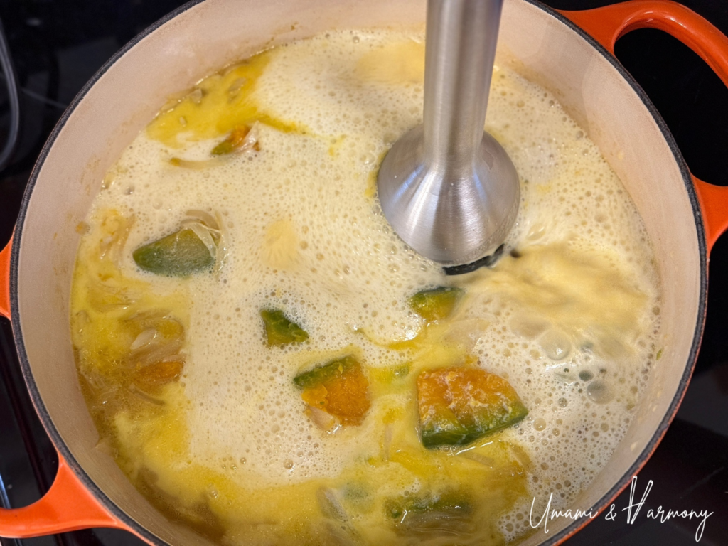 Immersion blender pureeing the kabocha squash soup until smooth
