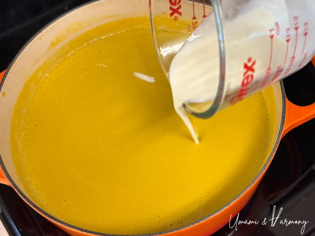 Heavy cream being added to the blended kabocha soup