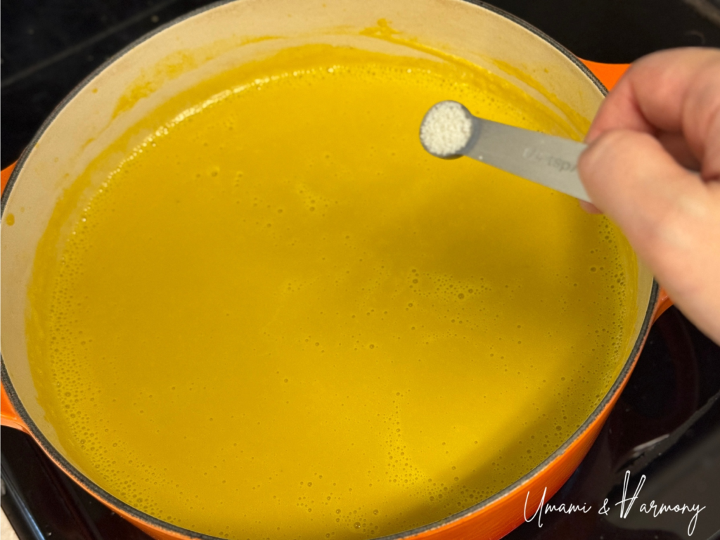 Salt and sugar being added to kabocha soup to adjust the taste