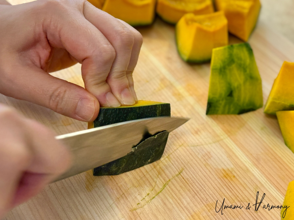 Removing the green skin from kabocha squash with a knife