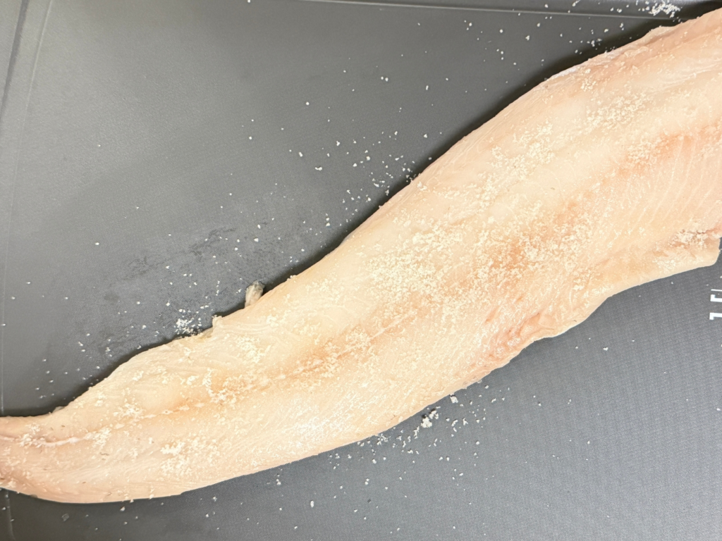 Black cod sprinkled evenly with salt to cure before marinating