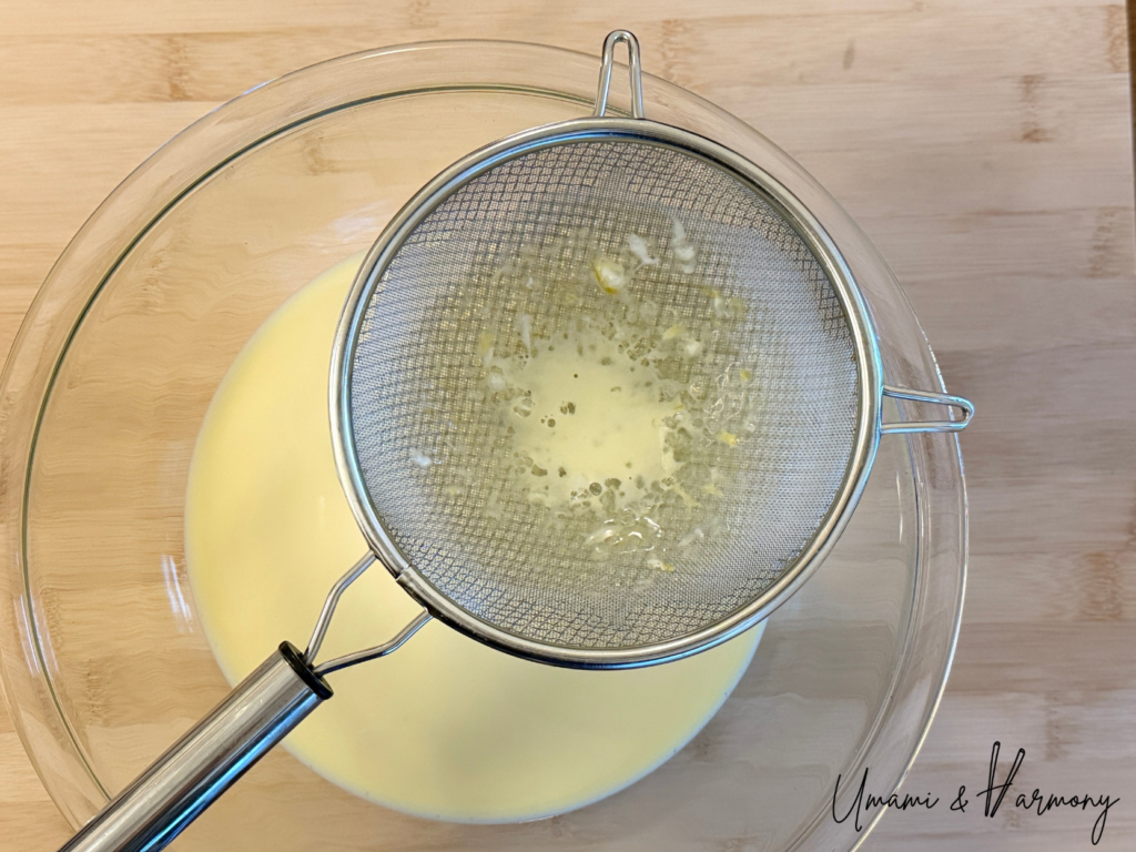 Custard mixture being strained through a fine sieve for smooth Purin
