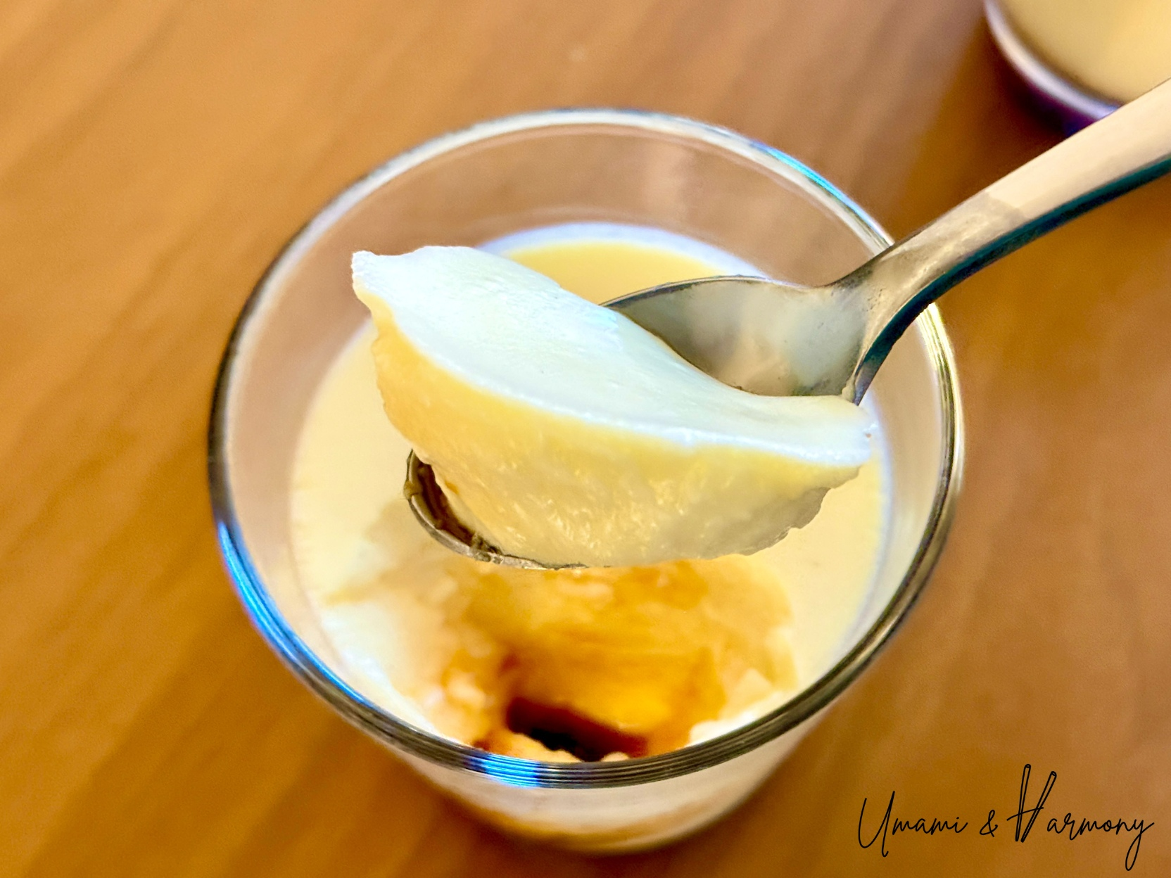 Japanese Purin being scooped with a spoon, showing caramel sauce at the bottom