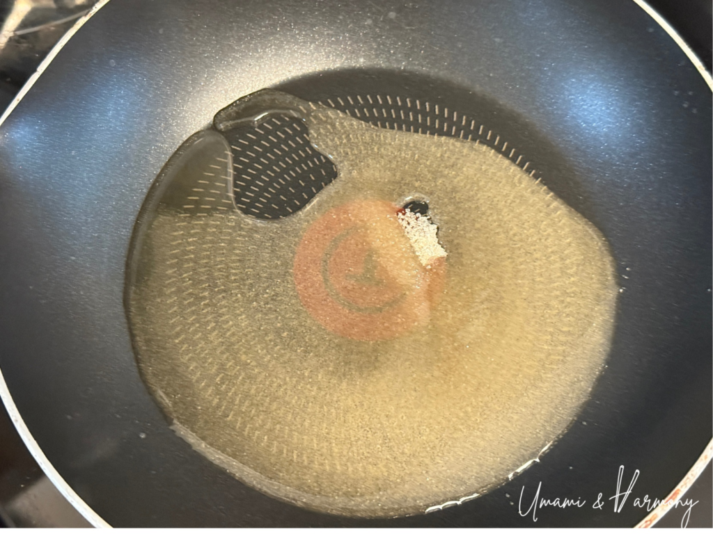 Sugar and water being heated in a pan to make caramel for Purin