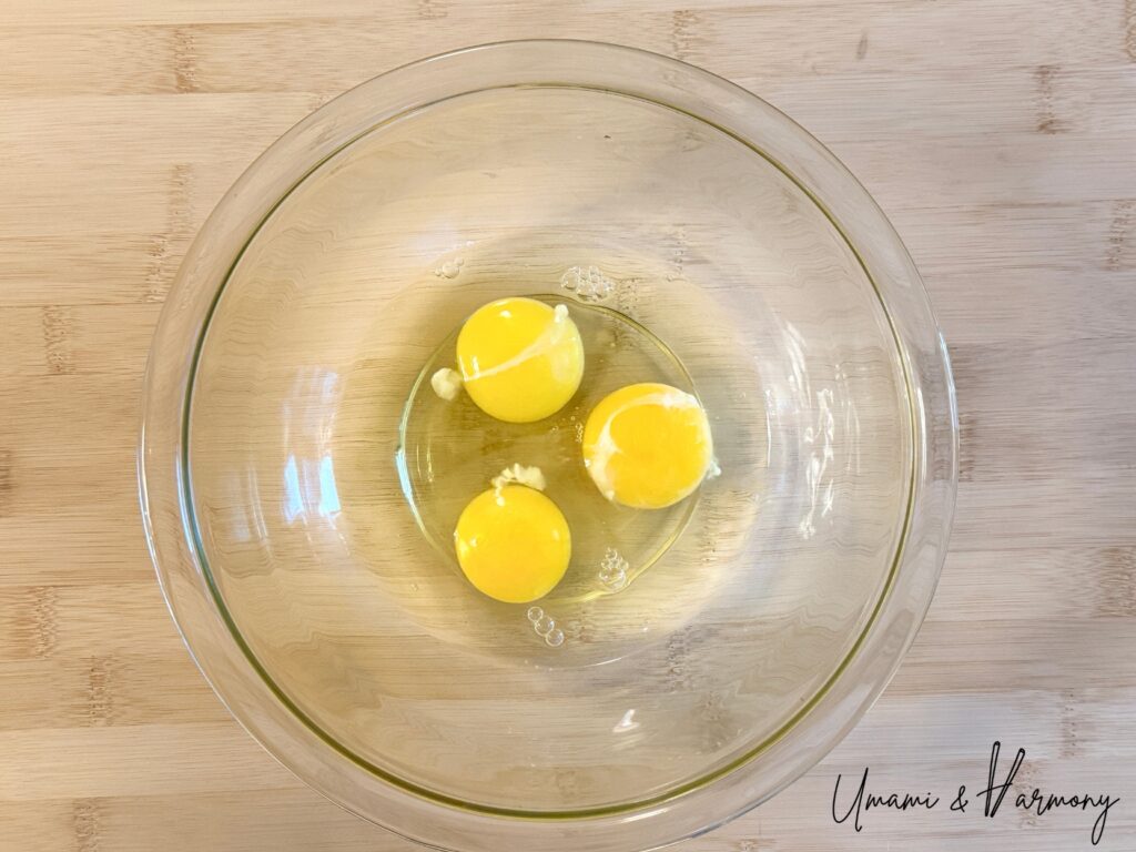 Three eggs cracked into a bowl for making Purin custard