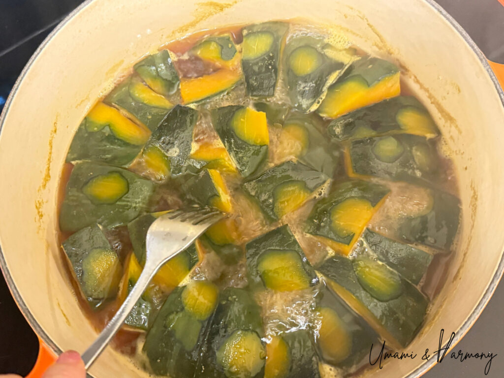 Fork piercing Kabocha piece to check tenderness