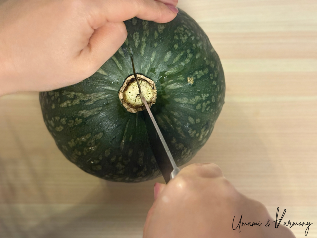 Whole Kabocha squash being cut in half. 