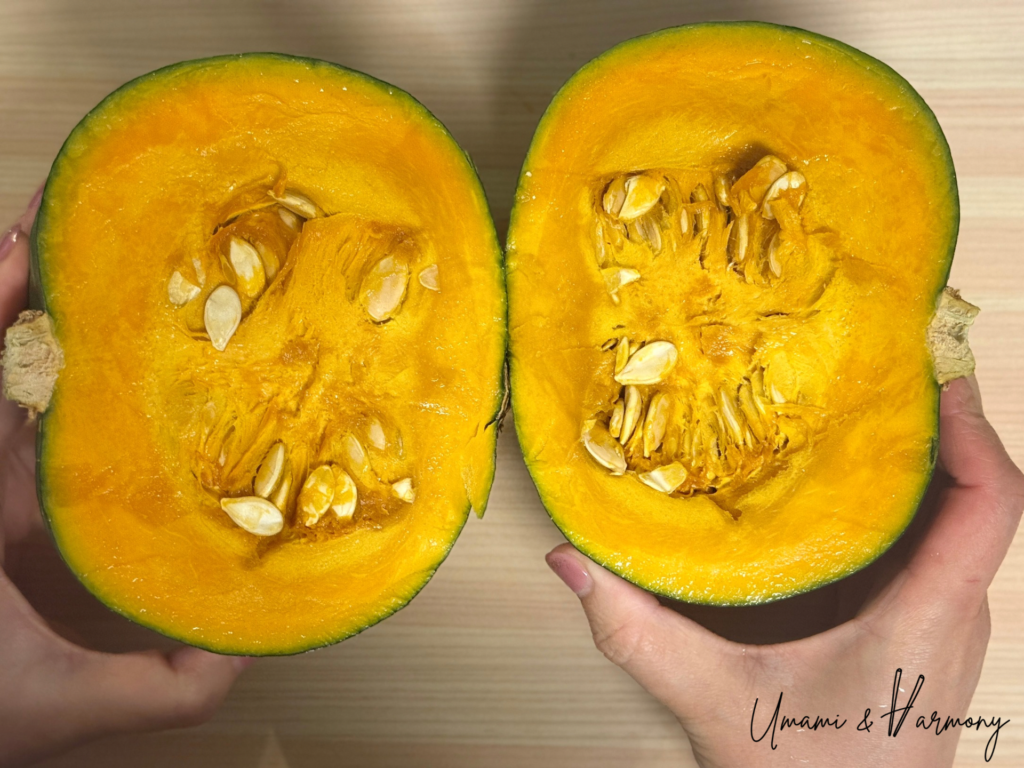 Kabocha squash cut in half showing bright orange flesh and seeds