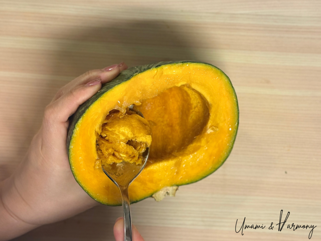 Kabocha fibers being cleaned out with a spoon. 