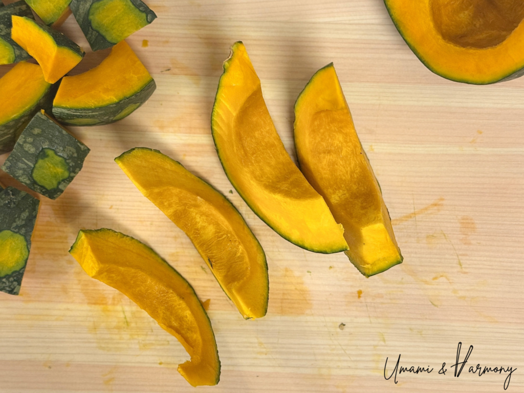 Kabocha squash being sliced into wedges on a cutting board