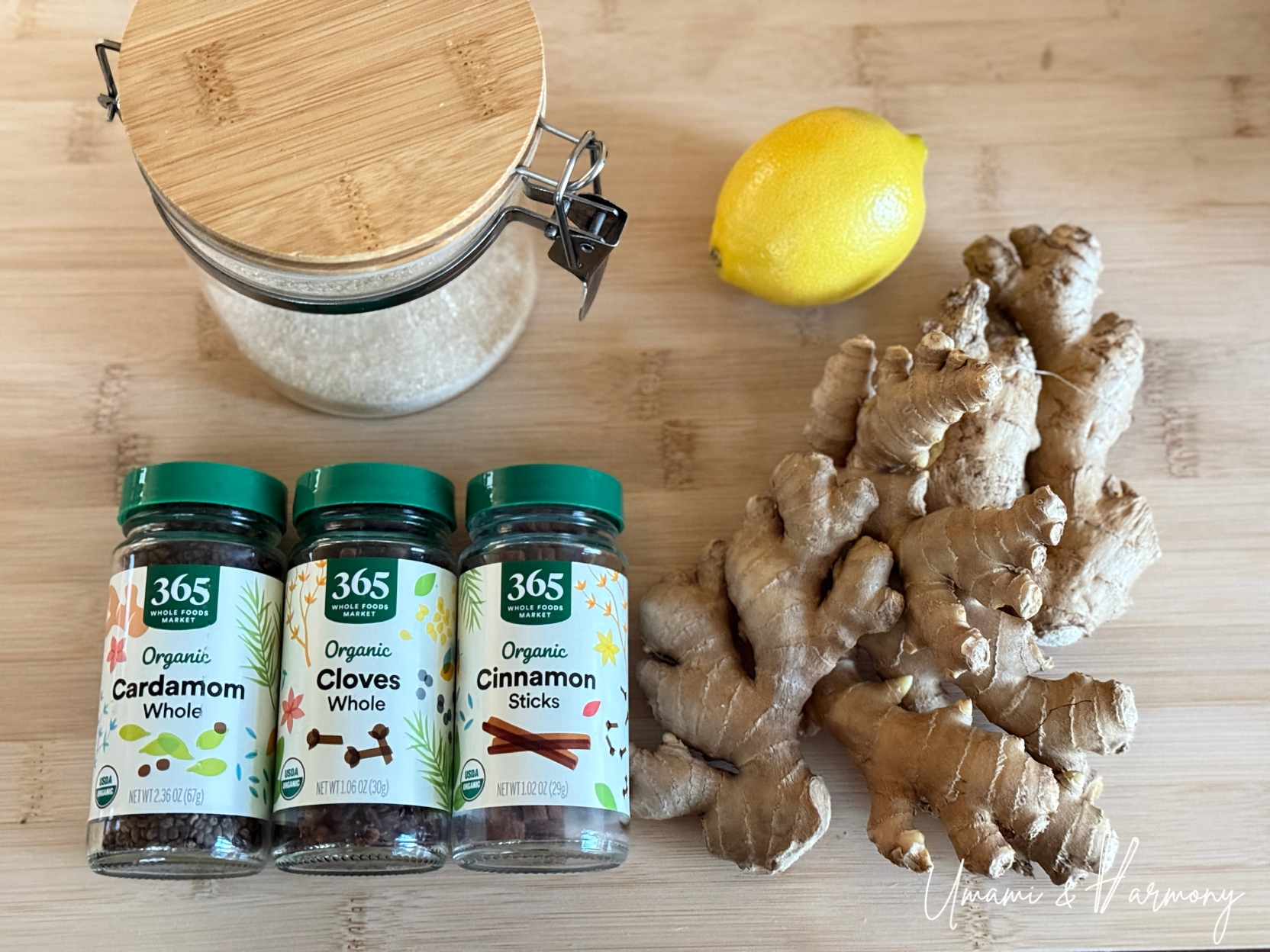 Ingredients for homemade ginger ale including fresh ginger, sugar, lemon, cinnamon sticks, cloves, and cardamom