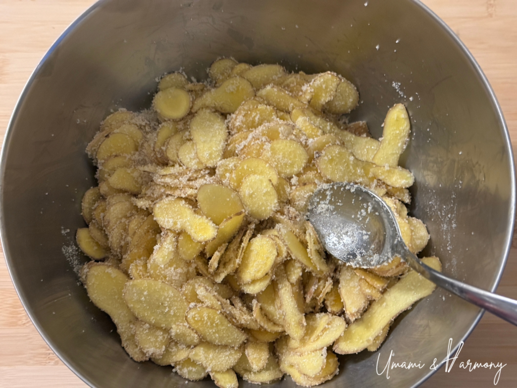 Sliced ginger and sugar mixed together in a bowl