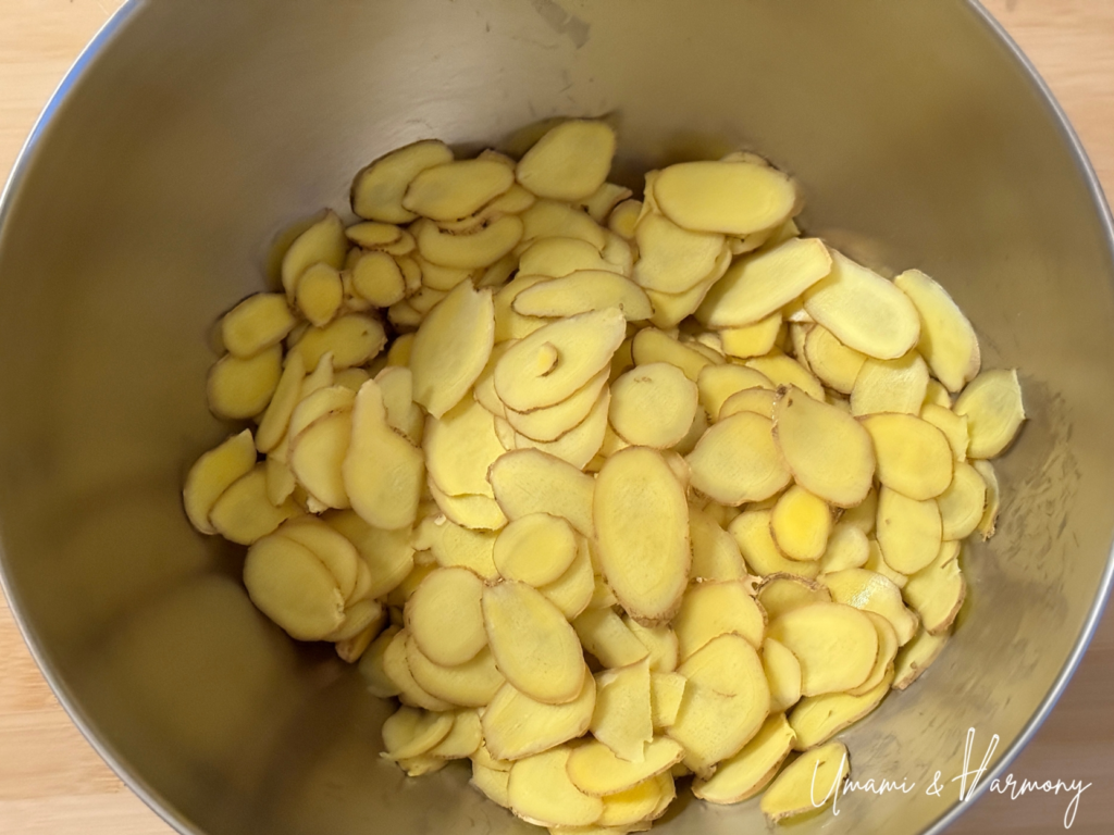 Sliced fresh ginger mixed with sugar in a bowl