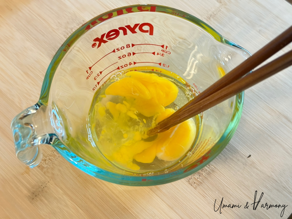 Eggs being beaten in a glass measuring cup