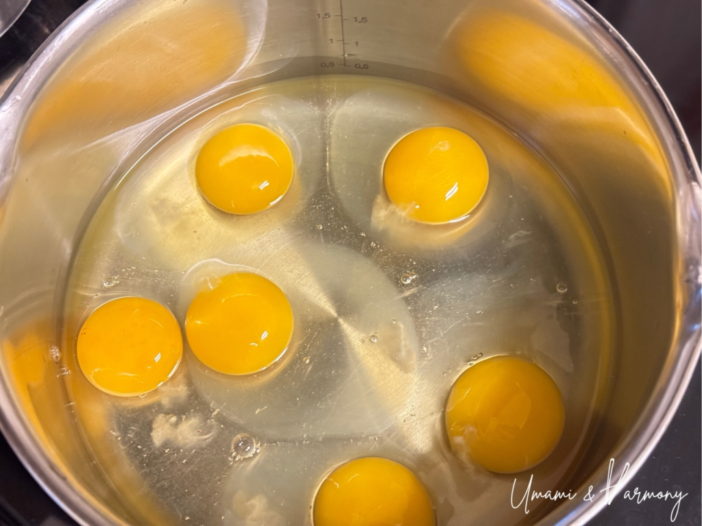 Eggs cracked into a pot before cooking