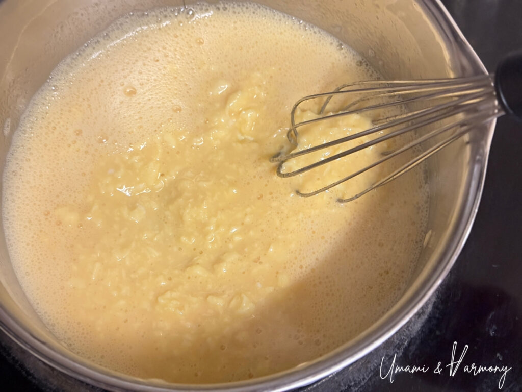 Egg mixture starting to cook while being stirred in a pot