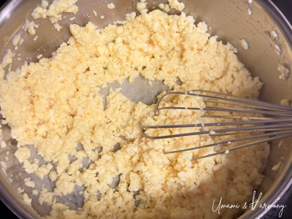 Egg mixture being stirred in a pot to create fluffy scrambled egg soboro