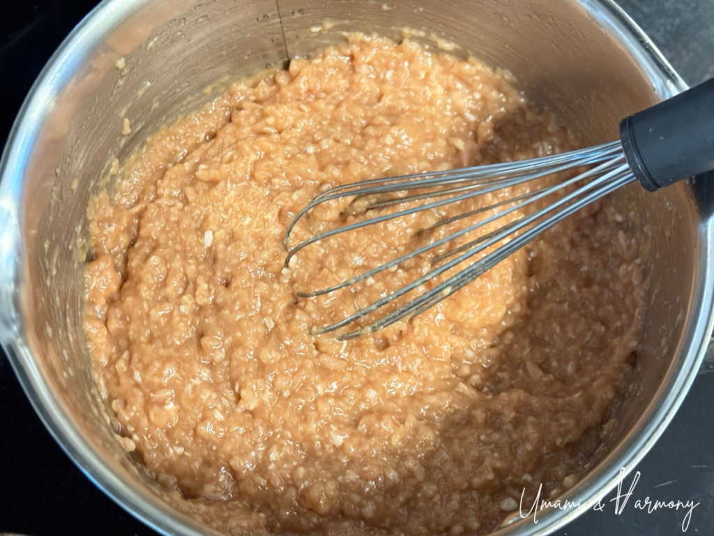 Ground chicken mixed with seasonings in a pot before cooking