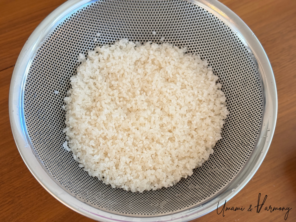 Rinsed Japanese rice draining in a colander