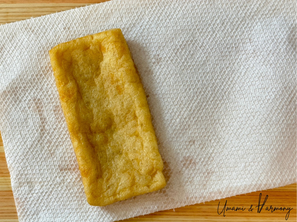 Abura-age being patted dry with paper towels