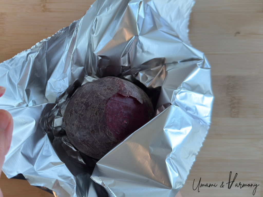 A beet being wrapped in aluminum foil