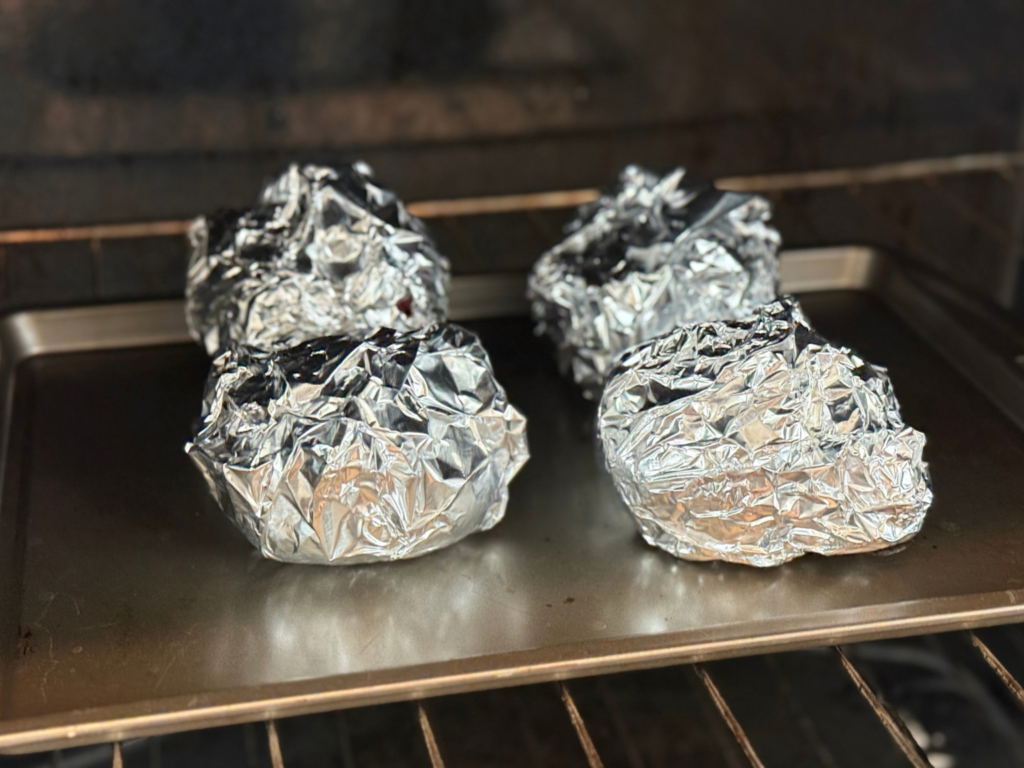 Wrapped beets on a baking pan in the oven