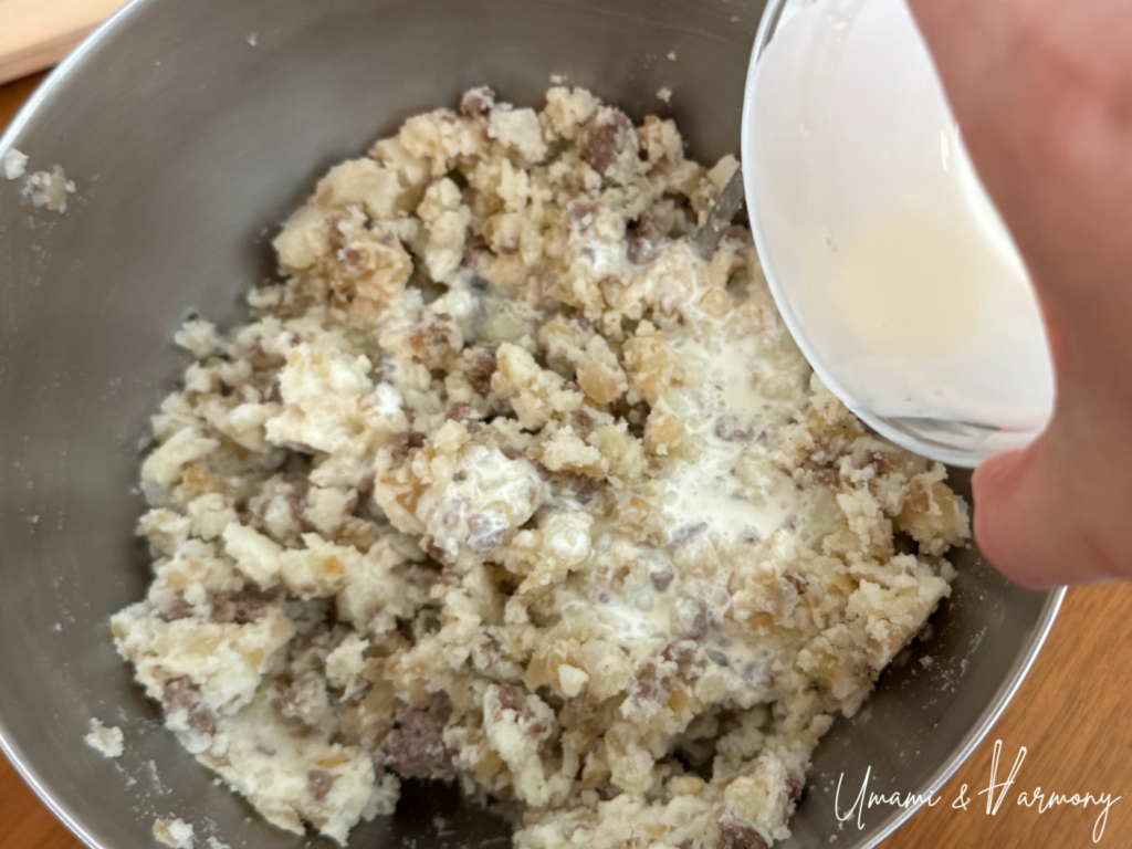 Seasonings and heavy cream being added to the mashed potato mixture