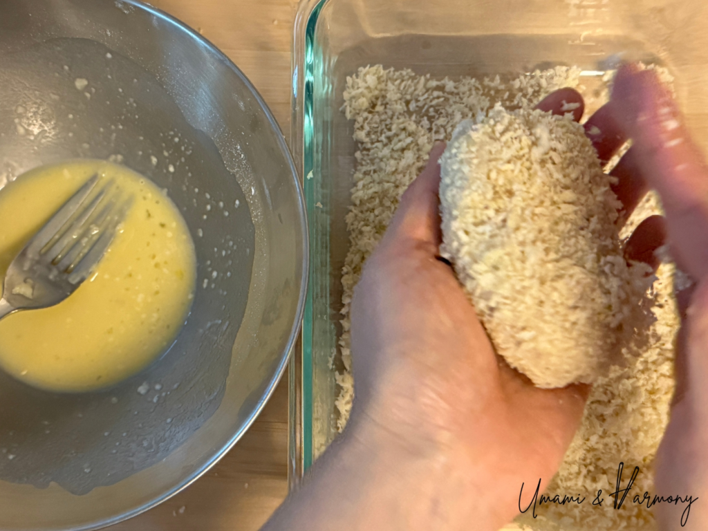 Croquettes being coated evenly with panko breadcrumbs