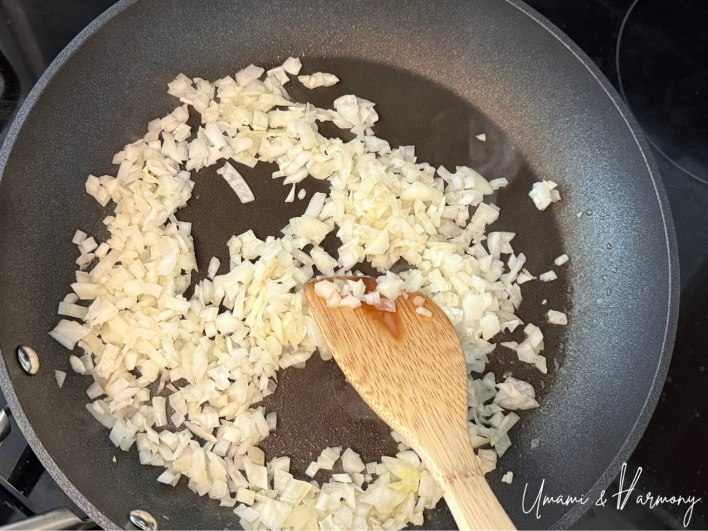 Chopped onion being sautéed in a pan