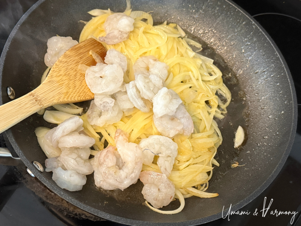 Shrimp added to the pan and sautéed with onions