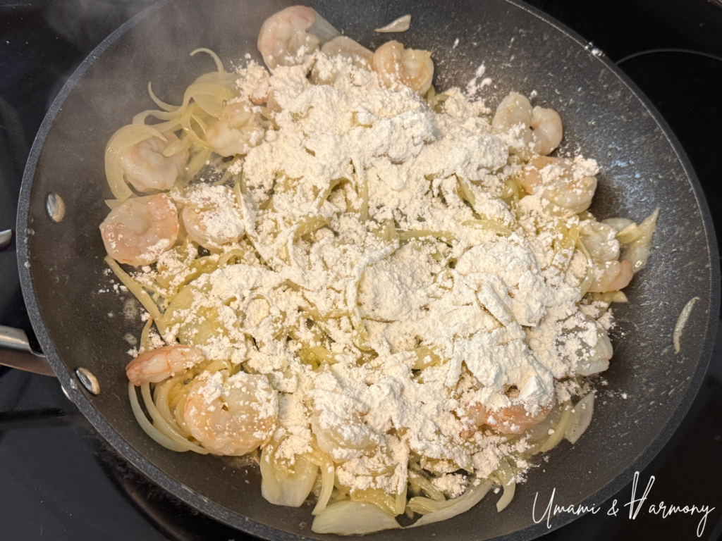 Flour added to shrimp and onion mixture to make the roux