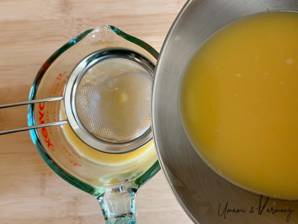 Egg mixture being strained through a fine mesh sieve