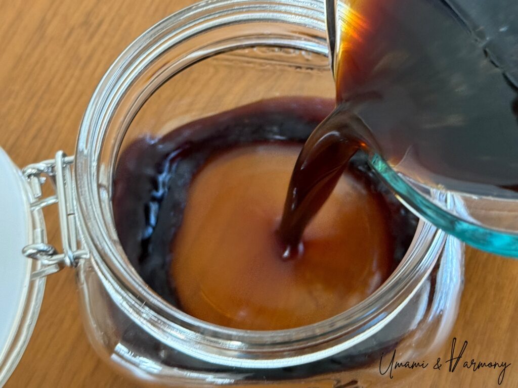 The citrus and soy sauce mixture being poured in a clean jar. 