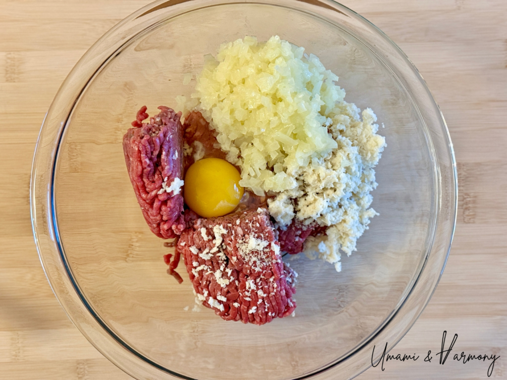 Ground beef, soaked panko, egg, and onion added to a bowl for hamburg steak mixture