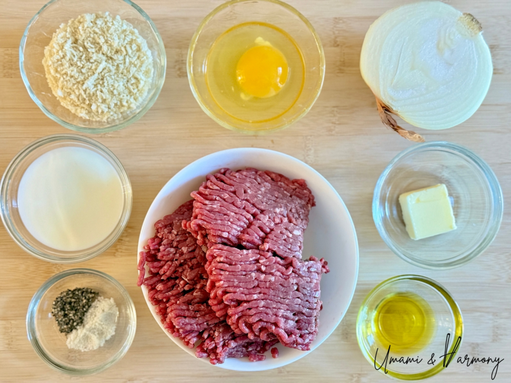 Ingredients for Japanese hamburg steak including ground beef, onion, egg, panko, milk, butter, and seasonings