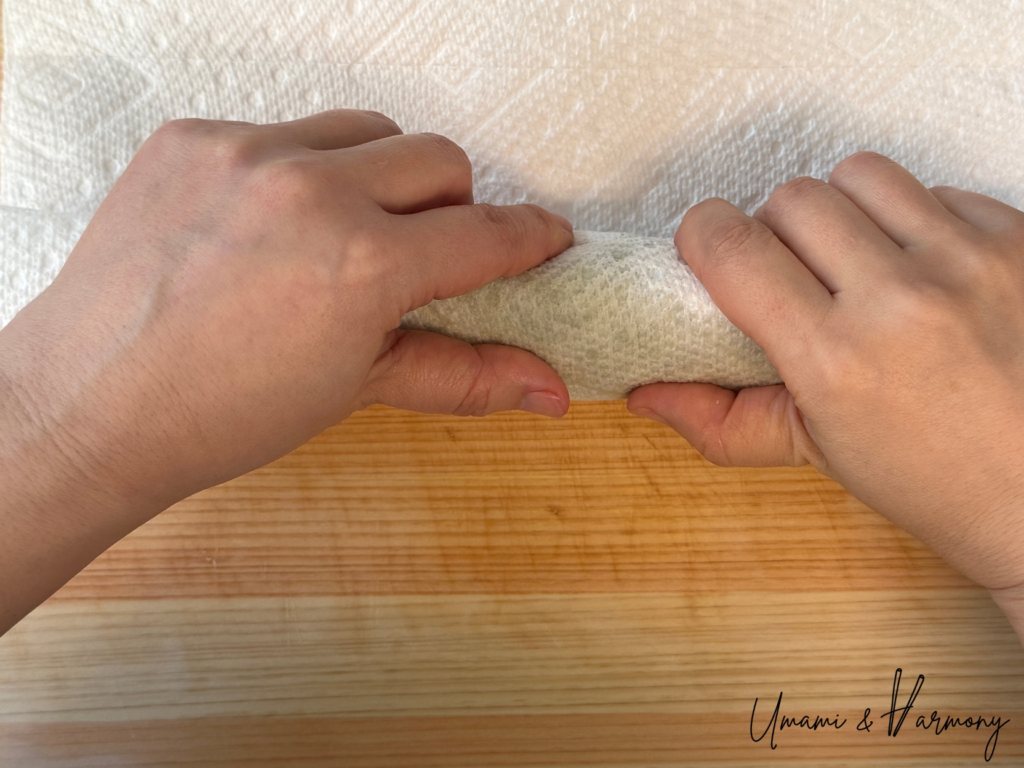 Spinach being gently pressed to squeeze out excess water