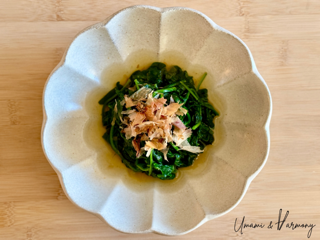 Spinach Ohitashi served in a bowl topped with bonito flakes