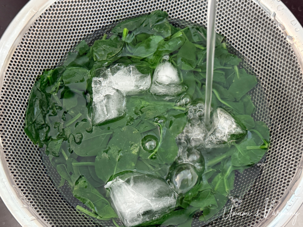 Blanched spinach being transferred to an ice bath