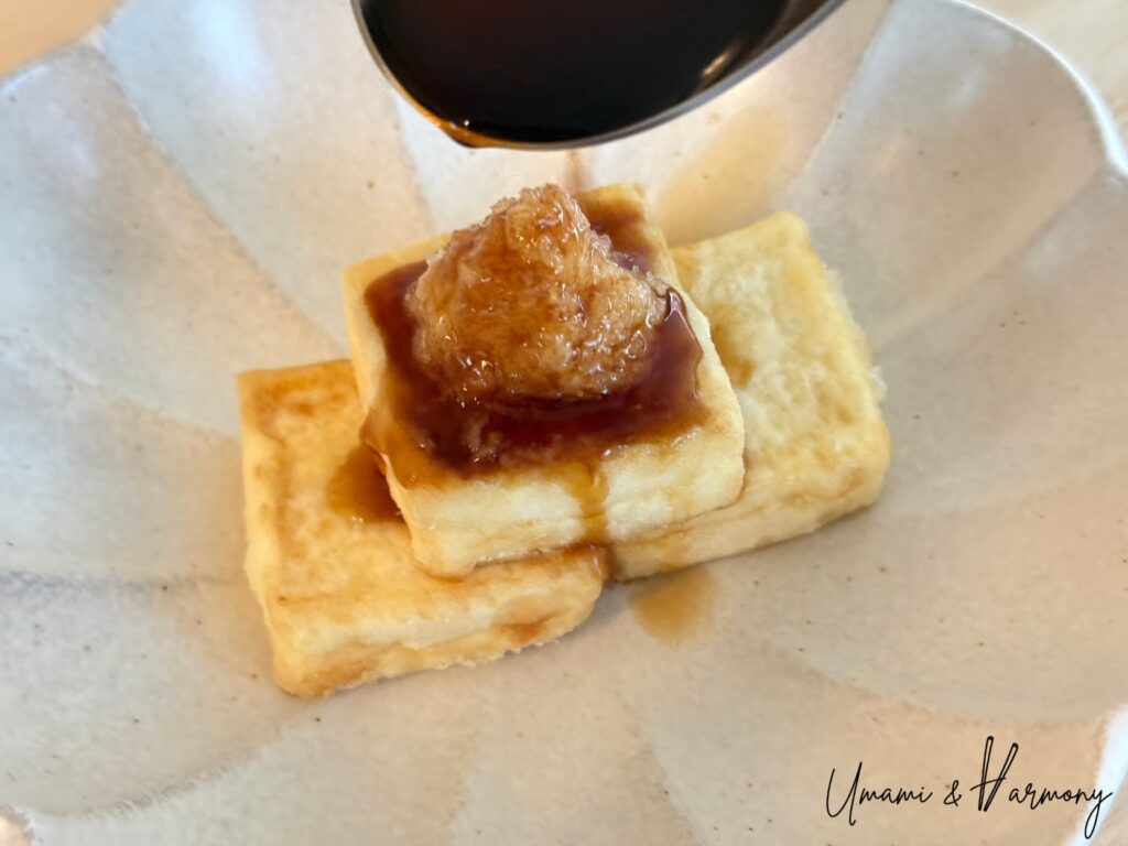Warm dashi sauce poured over agedashi tofu