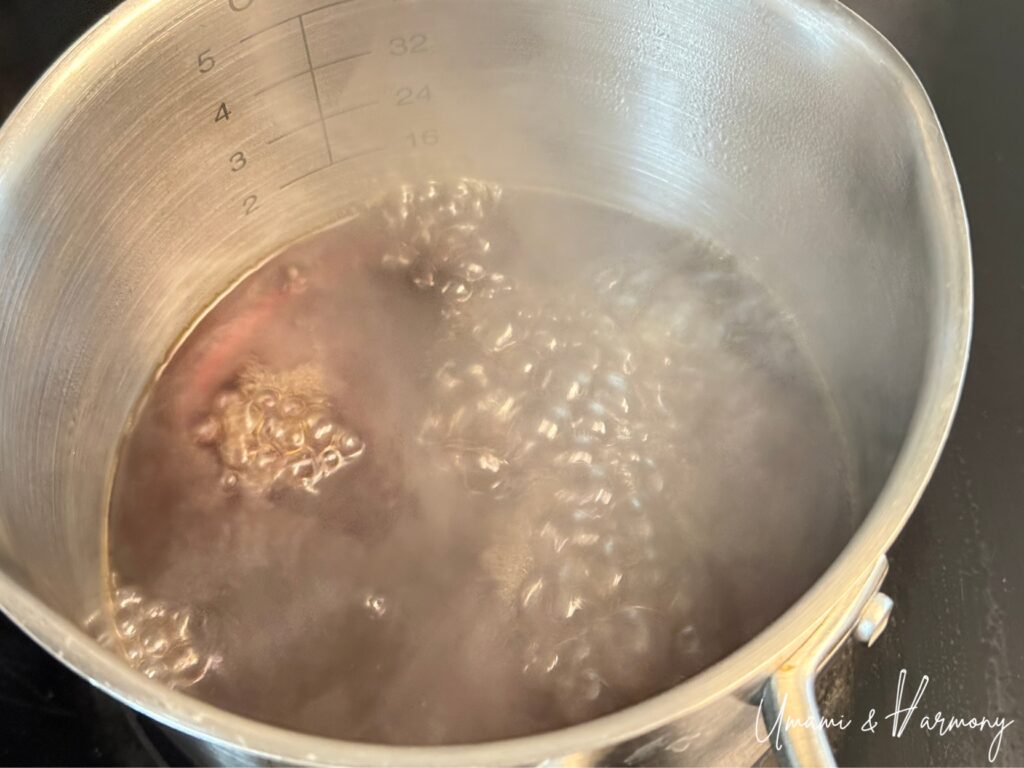 Dashi, mirin, and soy sauce being heated in a small pot