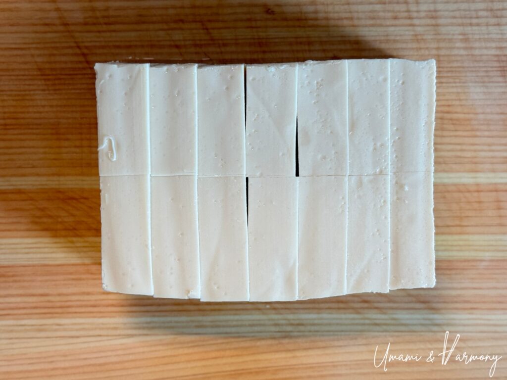 Tofu being cut into bite-sized pieces