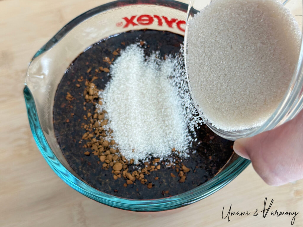 Instant coffee and sugar being mixed in hot water