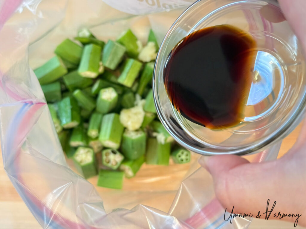 Soy sauce being poured into a bag of okra