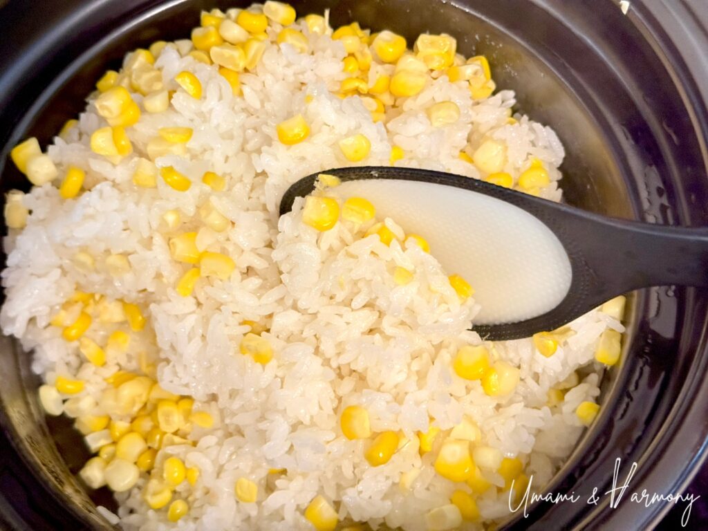 Fluffing Japanese corn rice with a rice paddle
