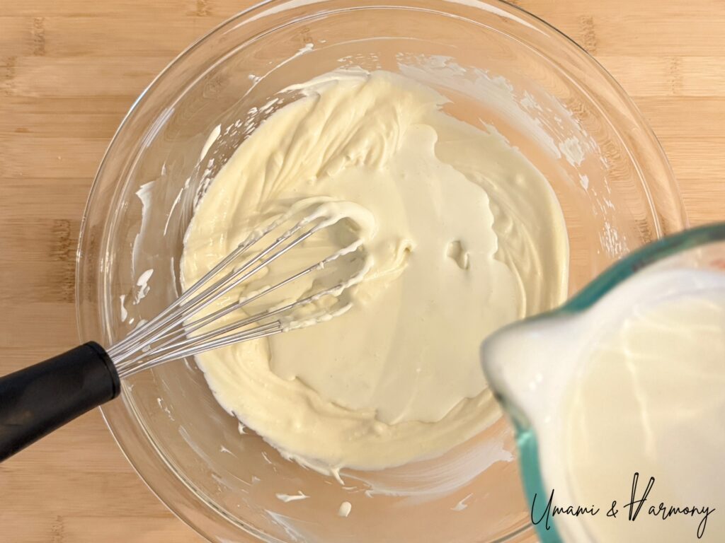 Heavy cream being mixed into cheesecake filling