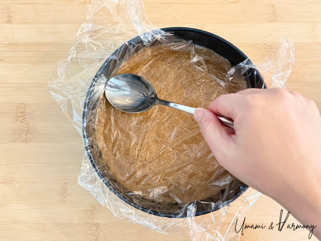 Compacting cheesecake crust edge with a spoon