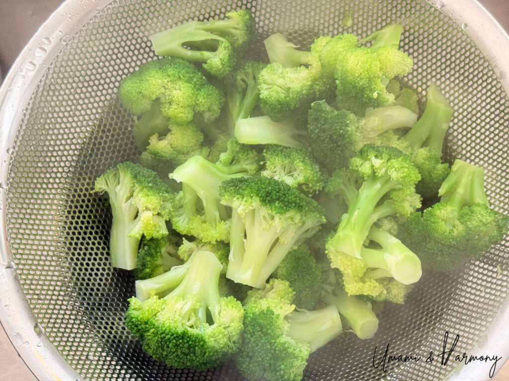 Draining cooked broccoli in a colander