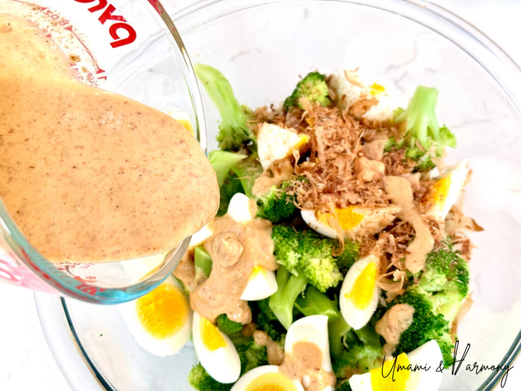 Creamy sesame mayo dressing being poured in the mixing bowl