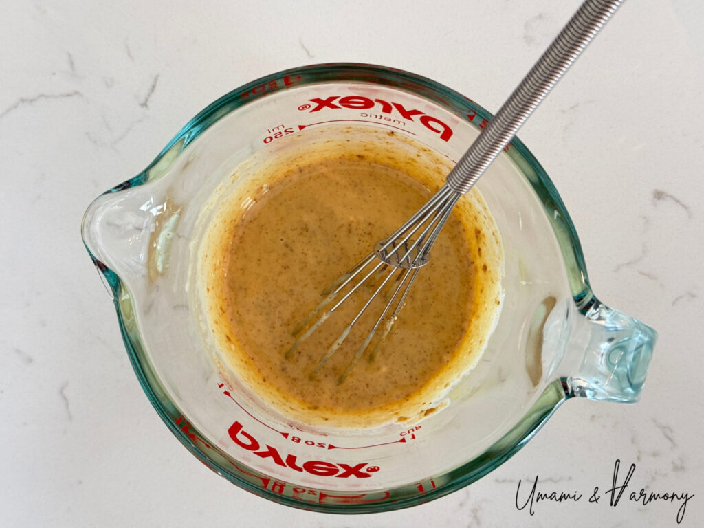 Mixing Japanese broccoli salad dressing with a small whisk