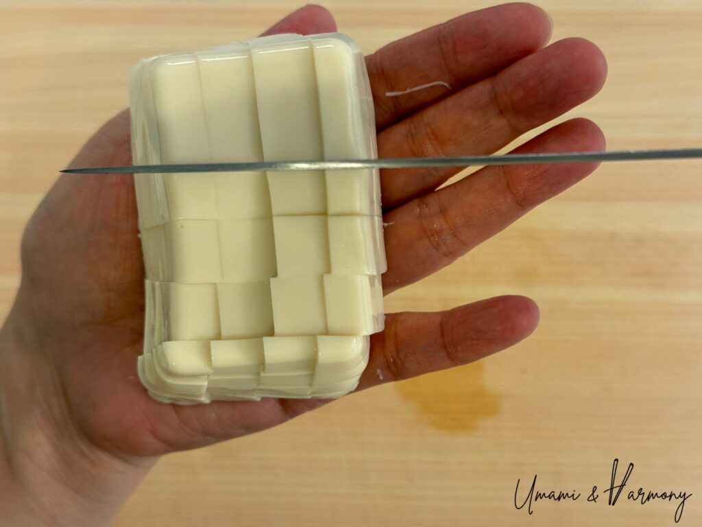 Tofu being carefully cut into small cubes for miso soup